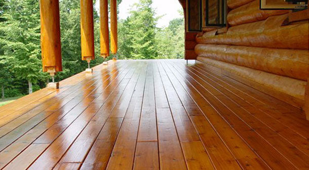 Log home deck with newly applied stain.